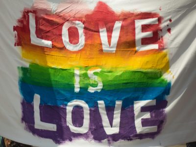 Colorful 'Love is Love' pride banner at a parade in London, Ontario celebrating equality and diversity.
