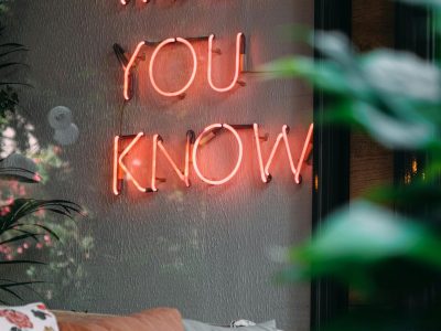A cozy indoor setting featuring a vibrant neon sign and plush cushions, blending modern design with comfort.