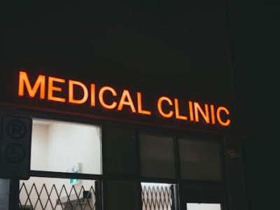 Bright neon medical clinic signage at night, creating a vivid street scene.